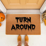 Spooky Halloween doormat with Turn Around text in a dripping black font, featuring a natural coir welcome mat on a porch with pumpkins and corn decor, perfect for fall home entryways and funny outdoor seasonal front door