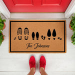 Personalized family doormat featuring footprints and paw prints on natural coir fiber, this custom welcome mat for front porch decor displays a family name and shoe prints for a unique housewarming gift for new homeowners and pet