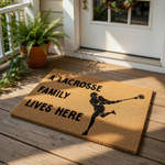 Lacrosse family doormat featuring a player silhouette and the text A Lacrosse Family Lives Here, this natural coir welcome mat is a durable outdoor floor rug for sports fans and makes a fun front porch decor for any lacrosse home.