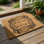Funny quote doormat featuring a decorative frame design and the text How You Doin, this natural coir fiber welcome mat is a stylish front porch rug for apartment entryways or home decor that adds a touch of humor to your entryway.