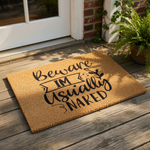 Funny Beware I'm Usually Naked coir doormat with black text, a perfect humorous welcome mat for your front porch or entryway that adds a cheeky touch to your home decor and makes a great housewarming gift for friends.