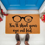 Funny holiday doormat featuring black glasses with a cracked lens and the text You will shoot your eye out kid, this natural coir welcome mat is a festive front porch decor piece for winter home entryways and seasonal