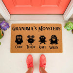 Personalized Grandma Monsters doormat featuring cute monster icons and custom names on a natural coir welcome mat, perfect for a front porch entry way decor gift for a grandmother who loves her grandkids and fun home accessories.