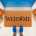 Halloween welcome doormat with a spooky jack-o-lantern pumpkin design, featuring natural coir fiber material for a front porch entry, perfect for fall seasonal home decor and outdoor entryway floor mat styling for the autumn