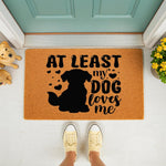 Dog lover welcome doormat featuring a black silhouette of a sitting dog and the text At Least My Dog Loves Me, this natural coir fiber outdoor entry rug is a funny pet owner home decor piece for your front porch or entryway floor.