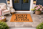 Funny Don't Need No Man doormat featuring bold black text on a natural coir welcome mat, displayed on a stone porch in a cozy outdoor entryway setting, perfect for a sassy home decor statement or a unique housewarming front door