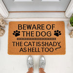 Funny dog and cat doormat with the text Beware of the Dog and The Cat Is Shady As Hell Too, featuring paw prints on a natural coir welcome mat for a front porch, perfect for pet owners who want a humorous outdoor entrance floor