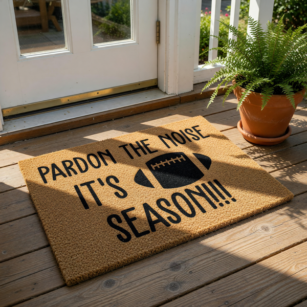Football season doormat with natural coir texture, featuring the text Pardon the Noise It's Football Season with a graphic of a football, perfect for a front porch entry rug or a fun sports fan home decor welcome mat for game day.