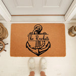 Personalized nautical anchor doormat featuring a custom family name on a natural coir welcome mat, perfect for a beach house or coastal home decor entrance, shown on a front porch with rope and lantern accents for a stylish