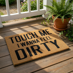 Funny doormat with the text Touch Me I Wanna Feel Dirty printed in bold black letters on a natural coir fiber welcome mat, perfect for a humorous front porch entrance or a cheeky housewarming gift for a home with a sense of humor.