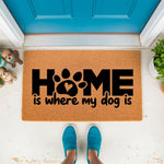 Home is where my dog is doormat with a paw print heart design, this natural fiber coir welcome mat for pet lovers features bold black text and sits on a porch floor, making a cute front door rug for dog owners and animal