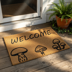Mushroom welcome doormat featuring a natural coir texture with black ink illustrations of three different fungi designs, making this a stylish outdoor entrance mat for a cottagecore or nature-inspired home front porch decor.