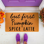 But First Pumpkin Spice Latte doormat for fall porch decor, featuring a natural coir welcome mat with black script text, surrounded by autumn leaves and orange pumpkins for a cozy seasonal entryway floor mat design.