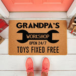 Grandpa's Workshop doormat featuring a wrench design and text reading Toys Fixed Free, this durable coir welcome mat is a fun front porch decor piece for a garage or hobby room entrance, perfect for a handy grandfather who loves