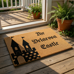 Personalized castle doormat featuring a black graphic of a fortress with towers on a natural coir welcome mat, perfect for a fantasy home entrance or custom housewarming decor that adds a unique touch to your front porch entryway.