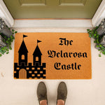 Personalized castle doormat with a custom family name, featuring a black fortress graphic on a natural coir welcome mat, perfect for a front porch entrance to add a stylish touch to your home decor and outdoor entryway floor mat.