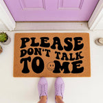 Funny doormat with Please Don't Talk To Me text and a smiley face icon, featuring a natural coir fiber texture for a front porch entry.