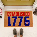 Established 1776 patriotic doormat for front porch entryways, featuring bold red and blue text on natural coir fiber.