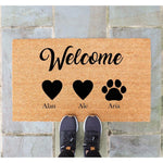 Personalized family welcome doormat with hearts and a pet paw print design on natural coir fiber, featuring custom text for a home entrance mat that makes a stylish front porch decor piece for dog lovers and pet owners.