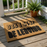 Funny doormat with the text Don't Stop Be Leaving printed in bold black letters on a natural coir fiber mat, creating a humorous welcome mat for your front porch or entryway that is sure to make guests laugh when they arrive at