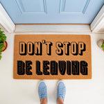 Funny doormat with bold black text reading Don't Stop Be Leaving, a natural coir fiber welcome mat for front porch decor that makes a humorous housewarming gift for guests and adds a playful touch to your home entryway floor.