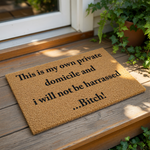 Funny rude doormat with text This is my own private domicile and i will not be harrassed...Bitch! printed in black on a natural coir fiber welcome mat, perfect for a front porch entry or a humorous home decor housewarming