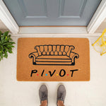 Coir doormat featuring a black couch illustration and the word PIVOT with colorful dots, serving as a funny welcome mat for front porch decor.
