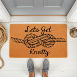Nautical doormat with a rope knot design and the text Lets Get Knotty, this funny welcome mat for front porch decor features a natural coir fiber texture and is perfect for a beach house or coastal home entryway floor mat.