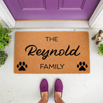 Personalized family name doormat with paw prints, a custom coir welcome mat for pet lovers featuring a durable natural fiber texture, perfect for a front porch entryway decor update that showcases your last name and love for dogs.