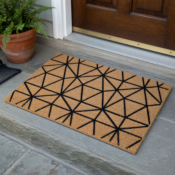 Geometric pattern coir doormat featuring a modern black triangular design printed on a natural brown coconut fiber background, providing a stylish and durable welcome mat for your front porch or entryway decor.