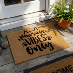 Pawsitive Vibes Only cat doormat made of natural coir fiber, featuring black printed text with cute cat ears and paw print accents on a simple white background for a fun and welcoming entryway decor for any pet lover home.