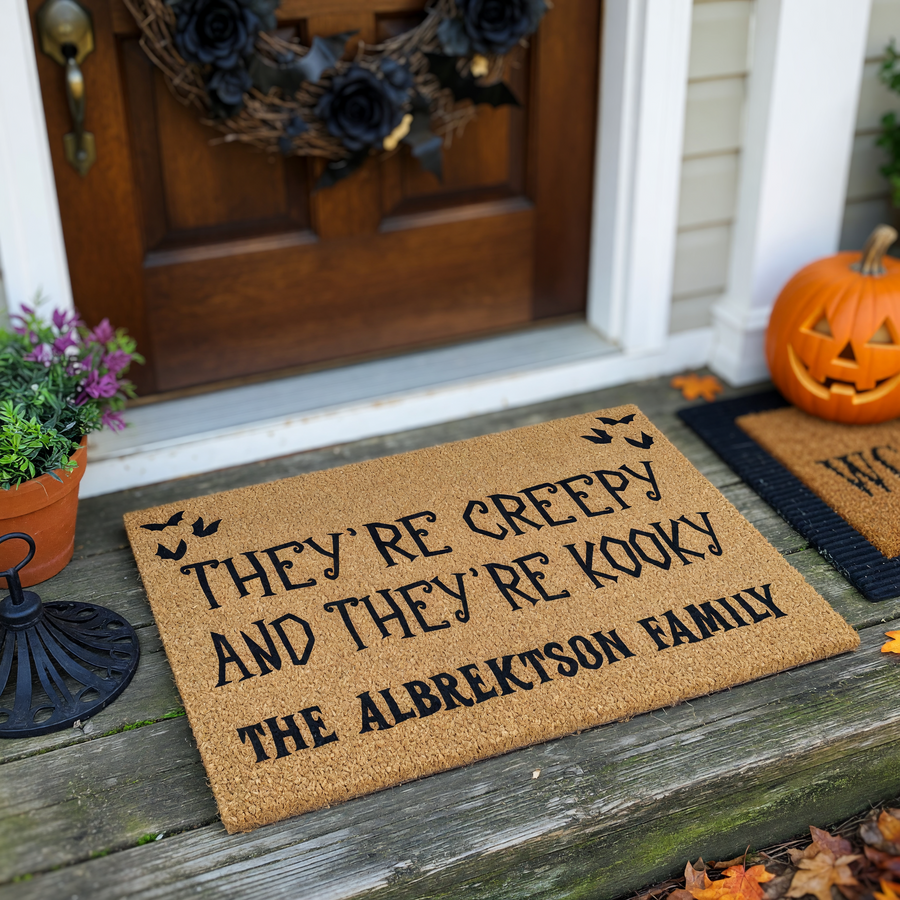 Personalized Halloween doormat featuring a natural coir texture with black text that reads They Are Creepy And They Are Kooky, customized with a family name, and decorated with small black bats in the top corners for a spooky