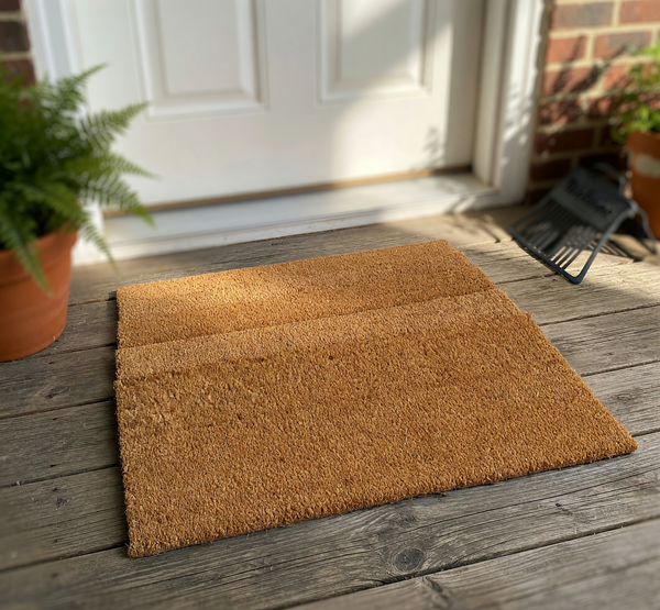 Natural coir fiber doormat showing a close-up corner view of the thick, durable material texture, featuring a clear measurement graphic indicating a half-inch thickness for this heavy-duty outdoor entrance mat on a plain white