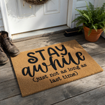 Funny Stay Awhile Doormat featuring a natural coir texture and bold black typography that reads Stay Awhile, followed by the humorous parenthetical text just not as long as last time, set against a clean and simple white studio