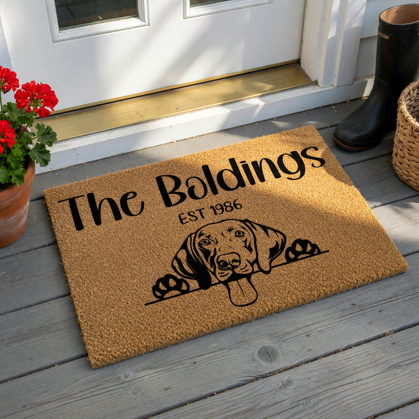 Personalized Dog Breed Coir Doormat featuring a cute Beagle peeking over a line with a family name and established year printed in black ink on a natural brown textured fiber background for a welcoming home entrance decor.