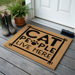 Cat People Live Here coir doormat featuring a playful black text design with paw print accents and a cat silhouette, set against a natural brown fiber background to welcome guests to a home filled with feline love and personality.