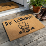 Personalized French Bulldog coir doormat featuring a cute dog illustration peeking over the edge, customized with a family name and established year in black ink on a natural brown textured fiber background for a welcoming home