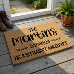 Personalized coir doormat featuring a humorous custom family name design with the text The Martins, followed by the phrase Eventually He Just Hasn't Asked Yet, printed in black ink on a natural brown textured coconut fiber