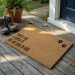 Funny Dog Lover Coir Doormat featuring the text There is like a bunch of big ass dogs in here printed in black ink, accented by two black paw prints on a natural brown textured coir fiber mat against a clean white studio