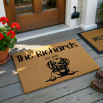 Personalized Labrador Retriever doormat featuring a natural coir texture with a black printed illustration of a happy dog peeking over a line, customized with a family name and established year on a clean white studio background.