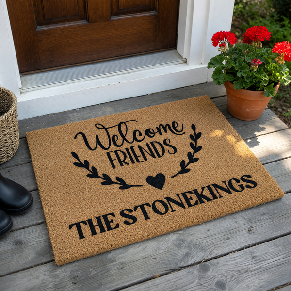 Personalized Welcome Friends doormat featuring a natural coir texture with black printed text and a decorative leaf wreath design, customized with a family name at the bottom to create a warm and inviting entryway for your home.