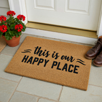 This is our Happy Place coir doormat features a natural tan fiber texture with bold black lettering centered on the mat, creating a welcoming front porch decor piece that adds a cozy touch to any home entryway or front door area.