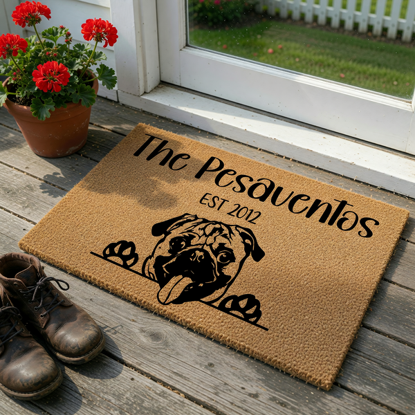 Personalized Pug welcome doormat featuring a cute illustrated dog peeking over a line with custom family name text and established year, crafted from natural coir fibers for a durable and charming entryway decor piece for any dog