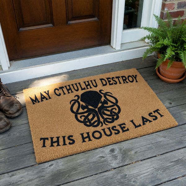 Cthulhu Horror Themed Doormat featuring a natural coir fiber texture with a black printed graphic of the mythical creature and the humorous text May Cthulhu Destroy This House Last centered on a plain white studio background.