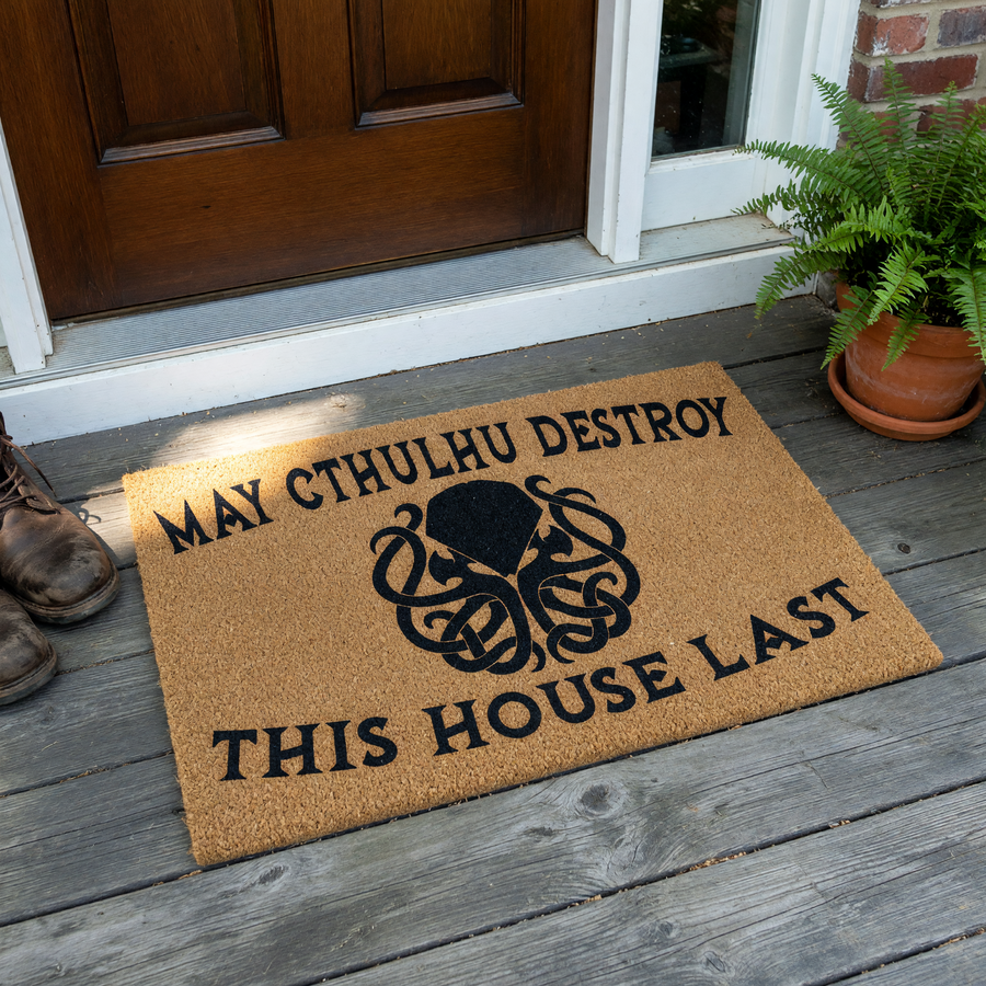 Cthulhu Horror Themed Doormat featuring a natural coir fiber texture with a black printed graphic of the mythical creature and the humorous text May Cthulhu Destroy This House Last centered on a plain white studio background.