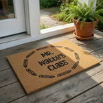 Personalized Teacher Classroom Doormat featuring a natural coir texture with a circular border of black pencil icons surrounding custom text that reads as a teacher's class name, perfect for a school entrance or classroom door