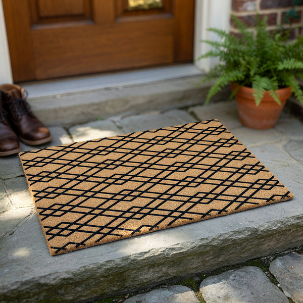 Geometric pattern coir doormat featuring a natural tan fiber texture with a bold black diamond lattice design, providing a modern and durable entryway floor covering for your home porch or front door area against a plain white