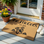 Personalized Bulldog Coir Doormat featuring a cute illustrated English Bulldog peeking over the bottom edge, with custom family name text and established year printed in black on a natural brown textured fiber background.