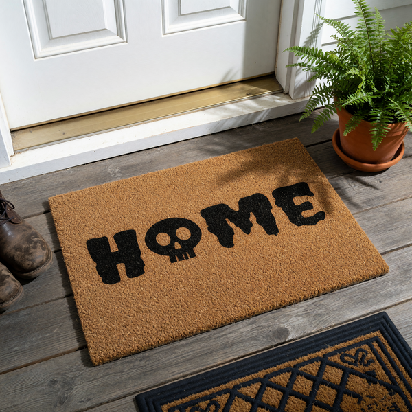 Skull Home Halloween Doormat featuring a natural coir fiber texture with the word HOME printed in bold black letters, where the letter O is replaced by a spooky skull icon, perfect for a gothic or seasonal front porch entryway