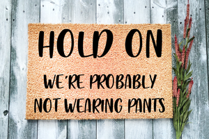 Hold On We're probably not wearing pants Funny Doormat